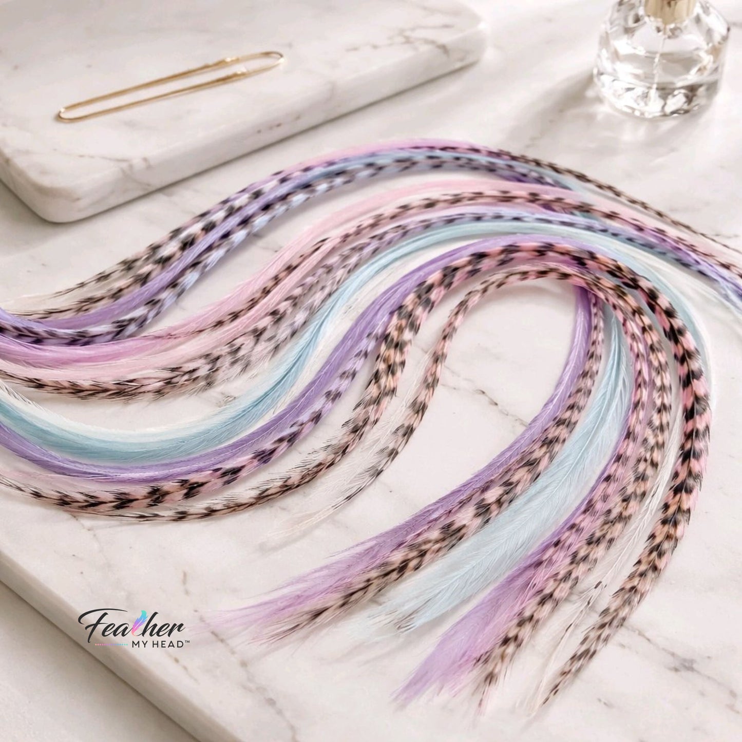 Frosted Cupcake feather hair extensions laid out in a pastel festival color mix.
