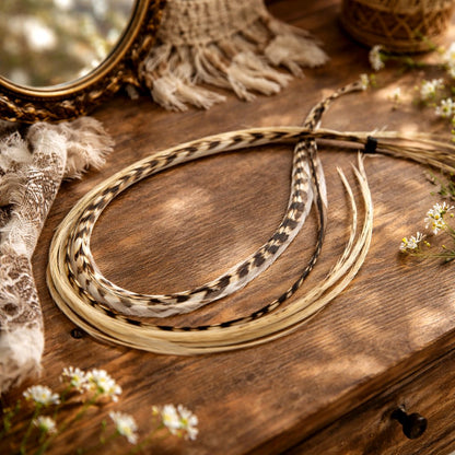 Island Girl feather hair extensions styled in a coiled bundle with soft cream, beige, and natural speckled feathers on a rustic wood surface