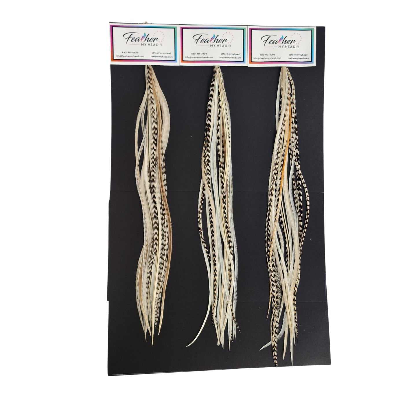 Island Girl feather hair extensions shown on display cards in soft cream, beige, and natural variegated tones