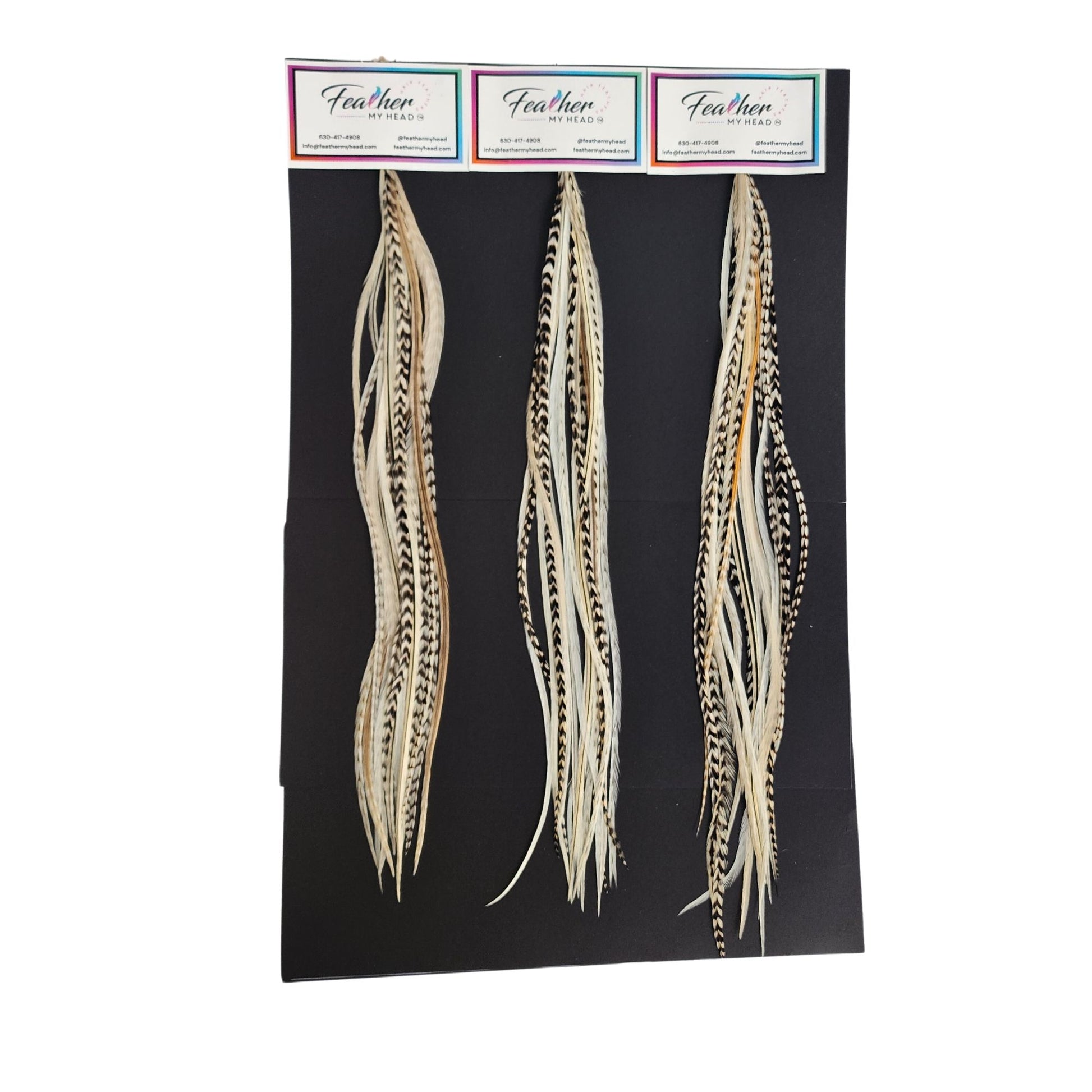 Island Girl feather hair extensions shown on display cards in soft cream, beige, and natural variegated tones