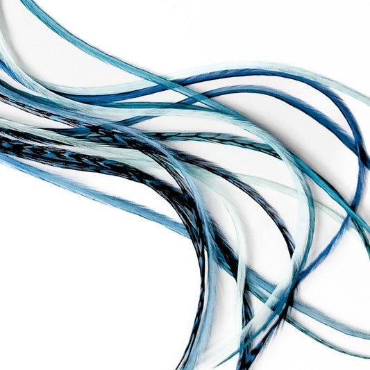 Long blue, aqua, and seafoam feather hair extensions in a soft coastal color blend